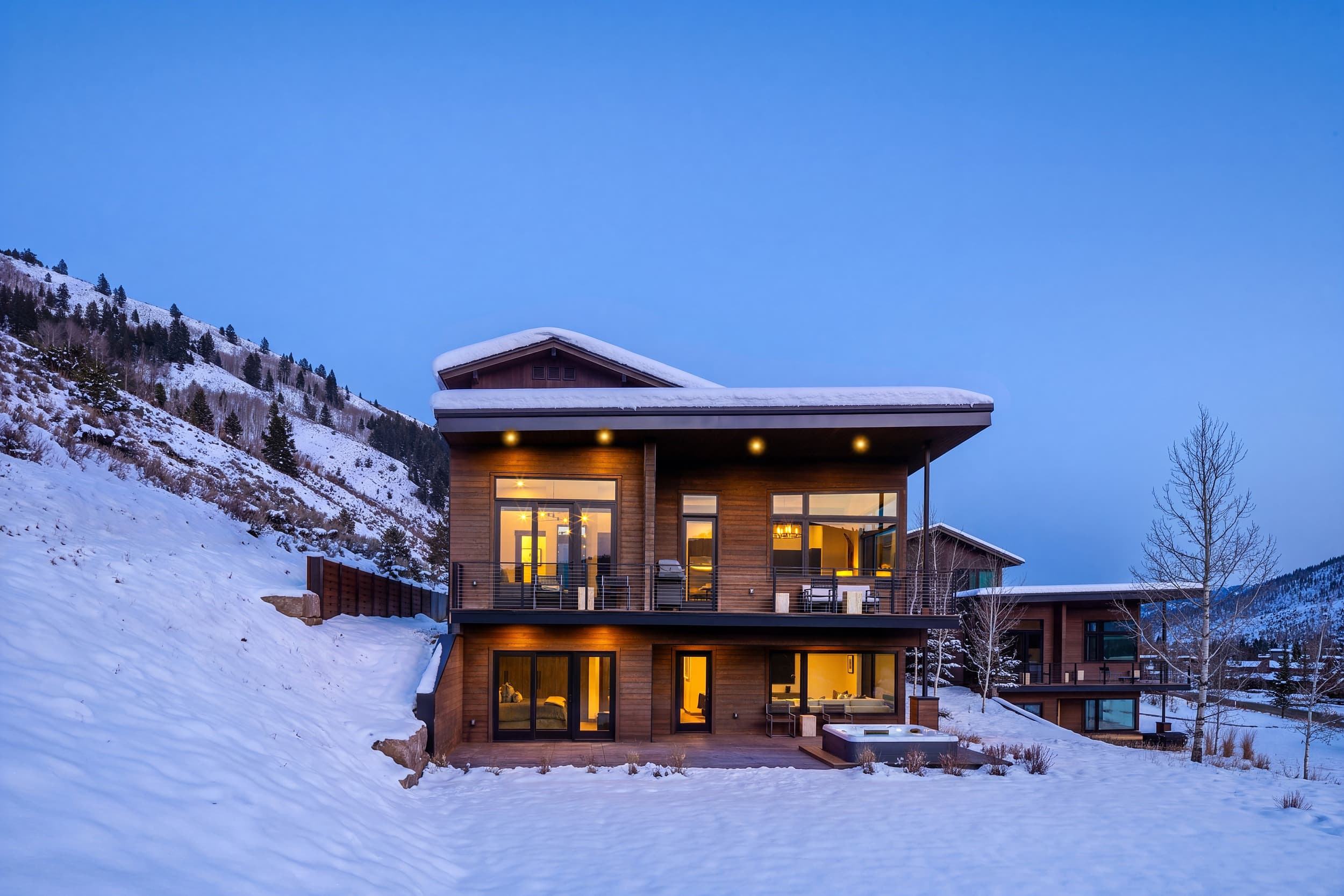 Modern mountain cabin with hot tub and deck in winter snow at Snake River Sporting Club, Jackson Hole