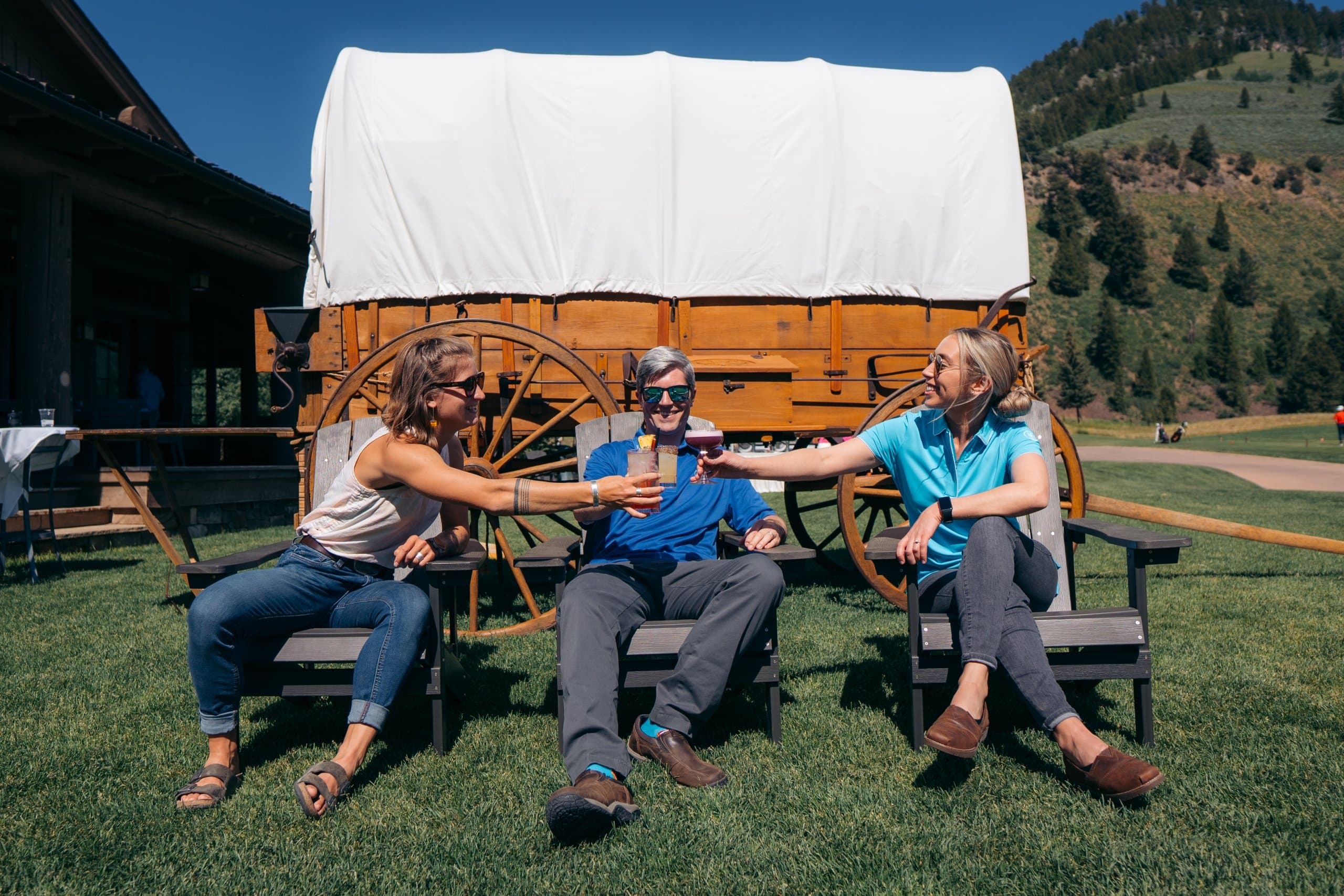 friends toasting with cocktails outside the clubhouse at Snake River Sporting Club
