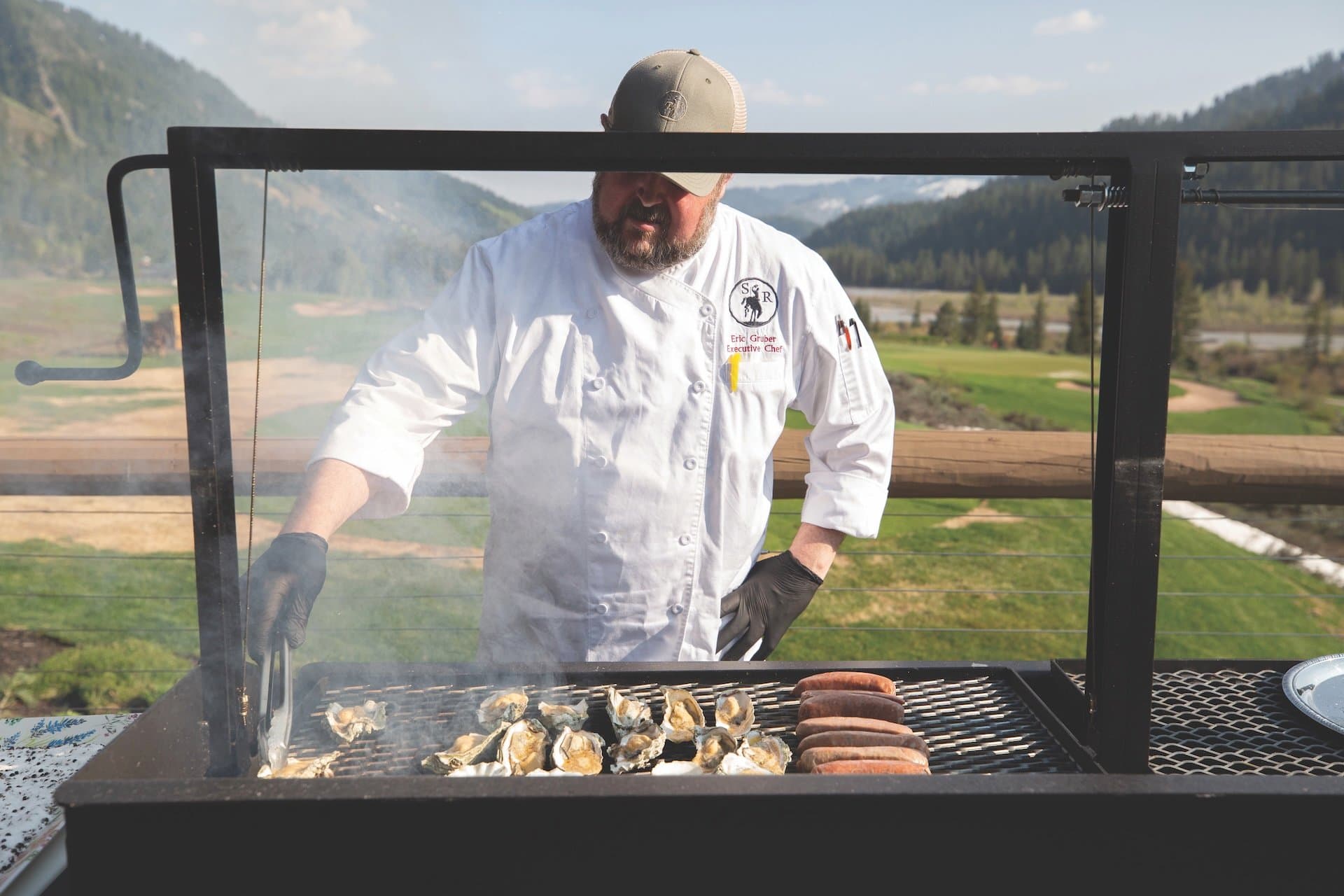 Chef Eric Gruber barbecuing outdoors at Snake River Sporting Club.