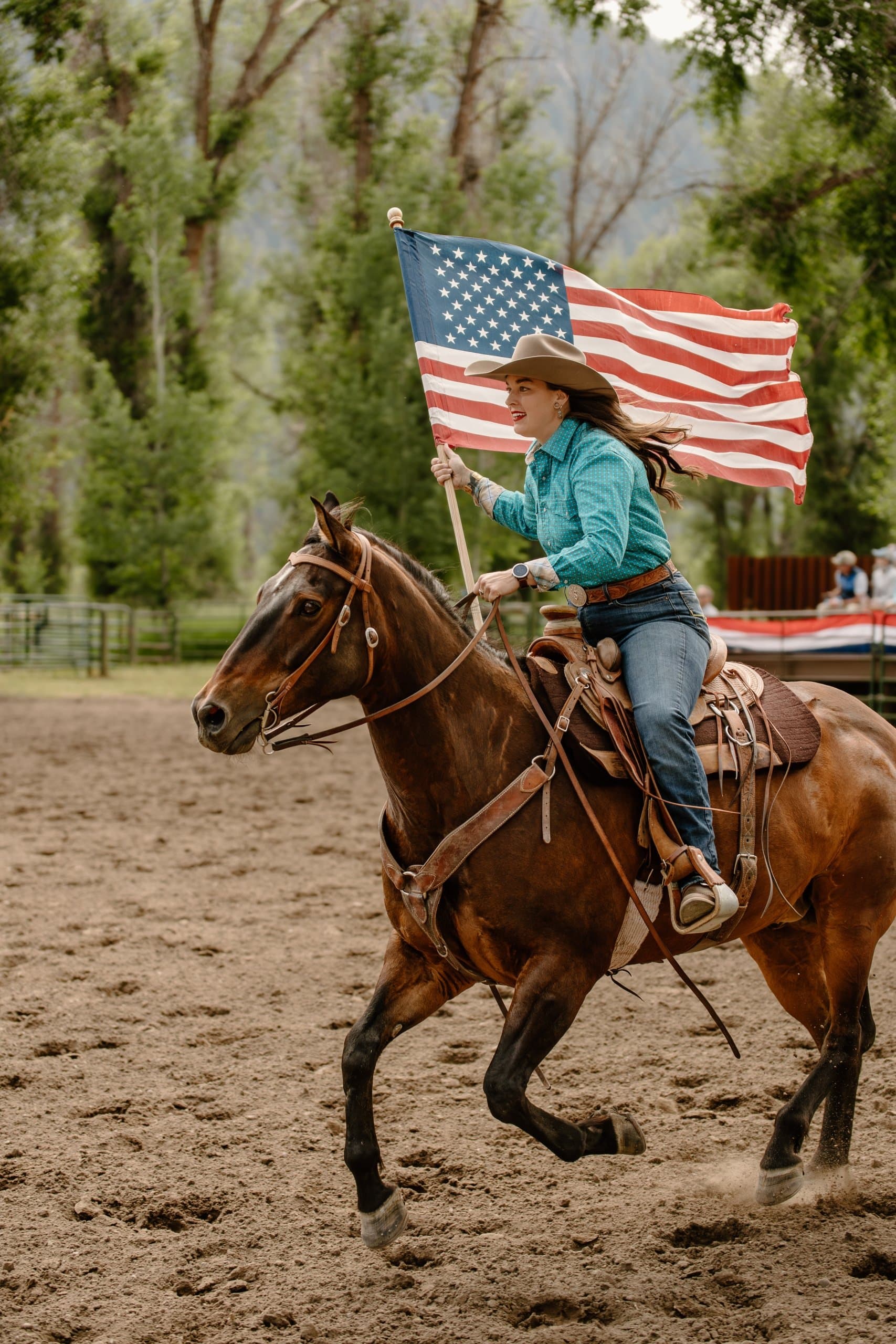 woman Horseback Riding holding an American flag in hand