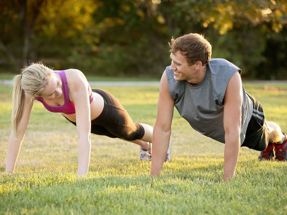 man & woman exercise on lawn