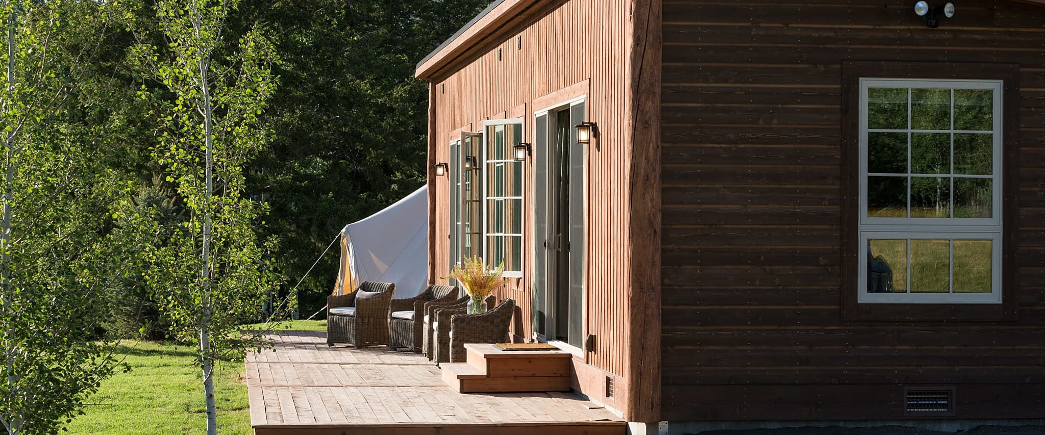 Cabin deck with wicker chairs at Snake River Sporting Club in Jackson Hole