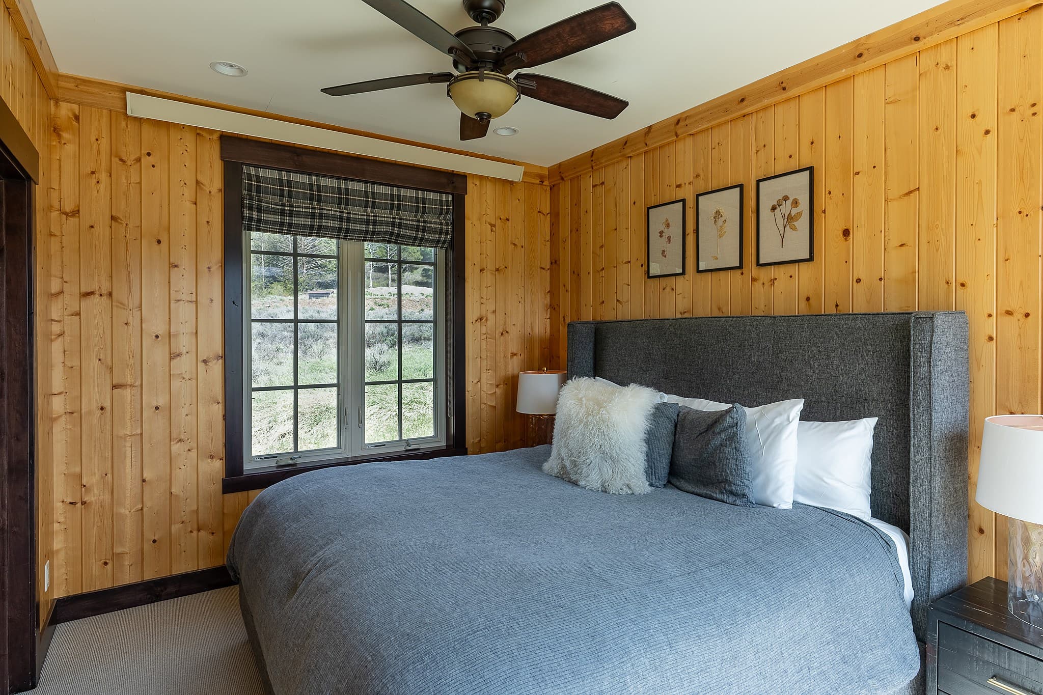 King bedroom with knotty pine walls in a Snake River Sporting Club cabin