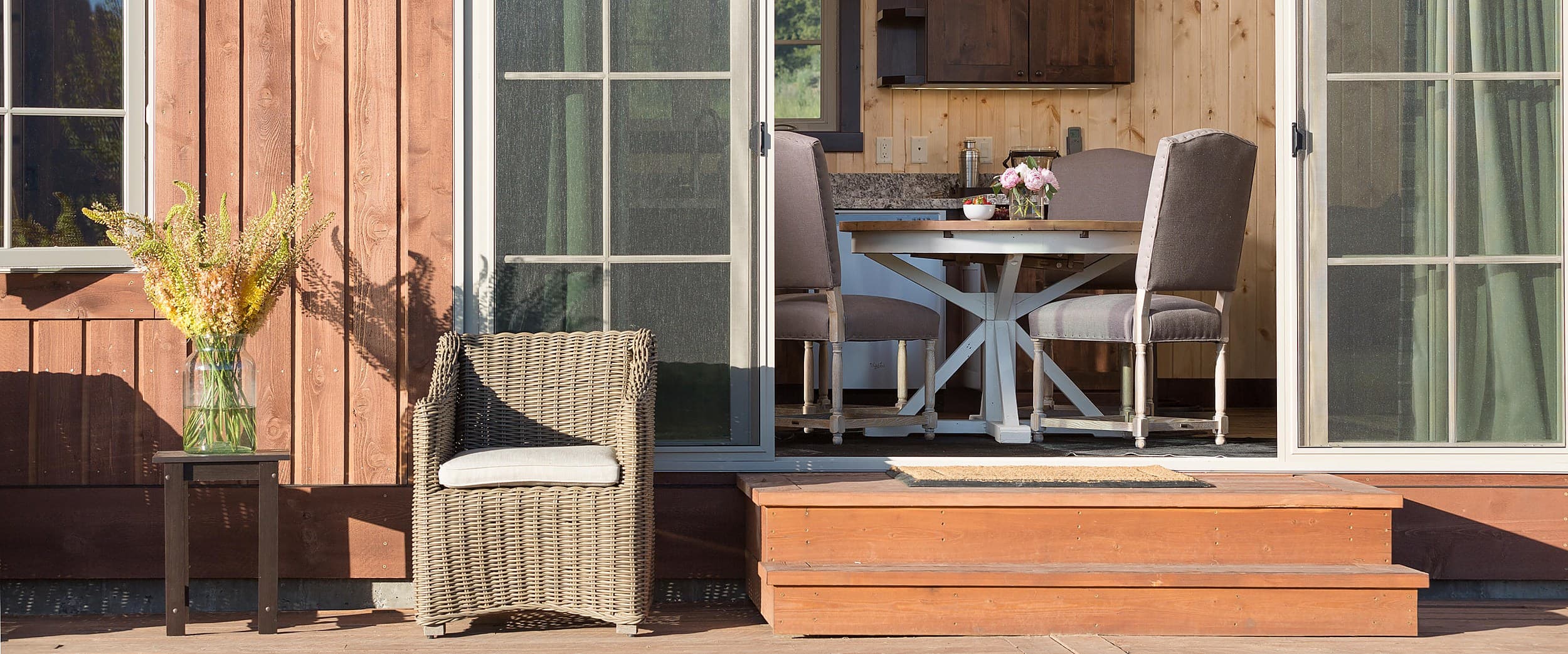 Cabin porch with wicker seating at Snake River Sporting Club in Jackson Hole