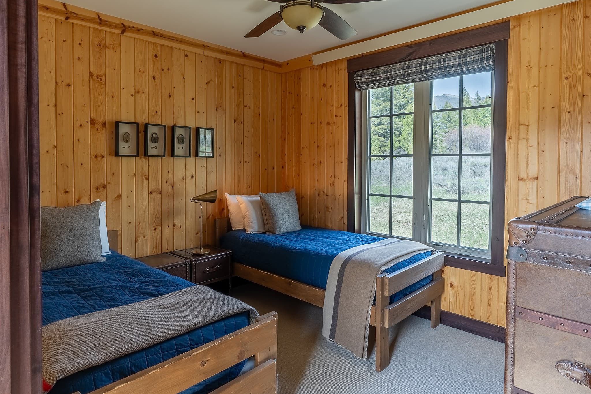 Twin bedroom with pine paneling in a Snake River Sporting Club cabin