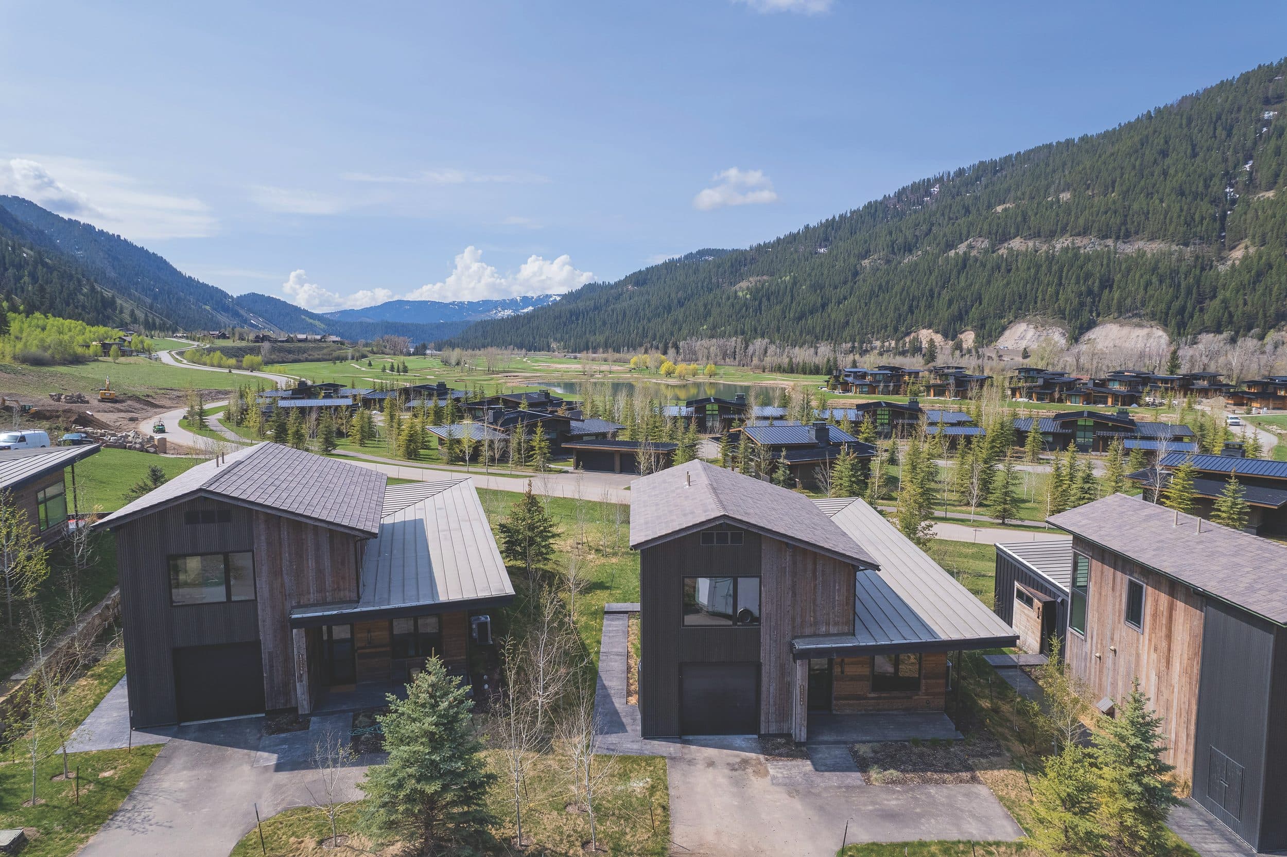 Aerial view of the Meadow Cabins at Snake River Sporting Club in Jackson Hole, Wyoming, framed by pine-covered mountains