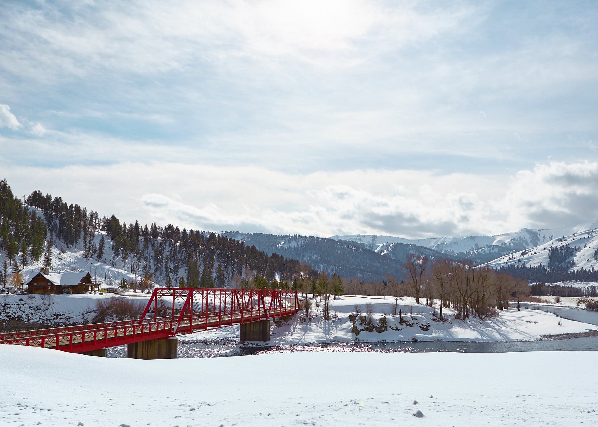Historic red truss bridge crossing the Snake River in winter snow near Snake River Sporting Club in Jackson Hole, Wyoming