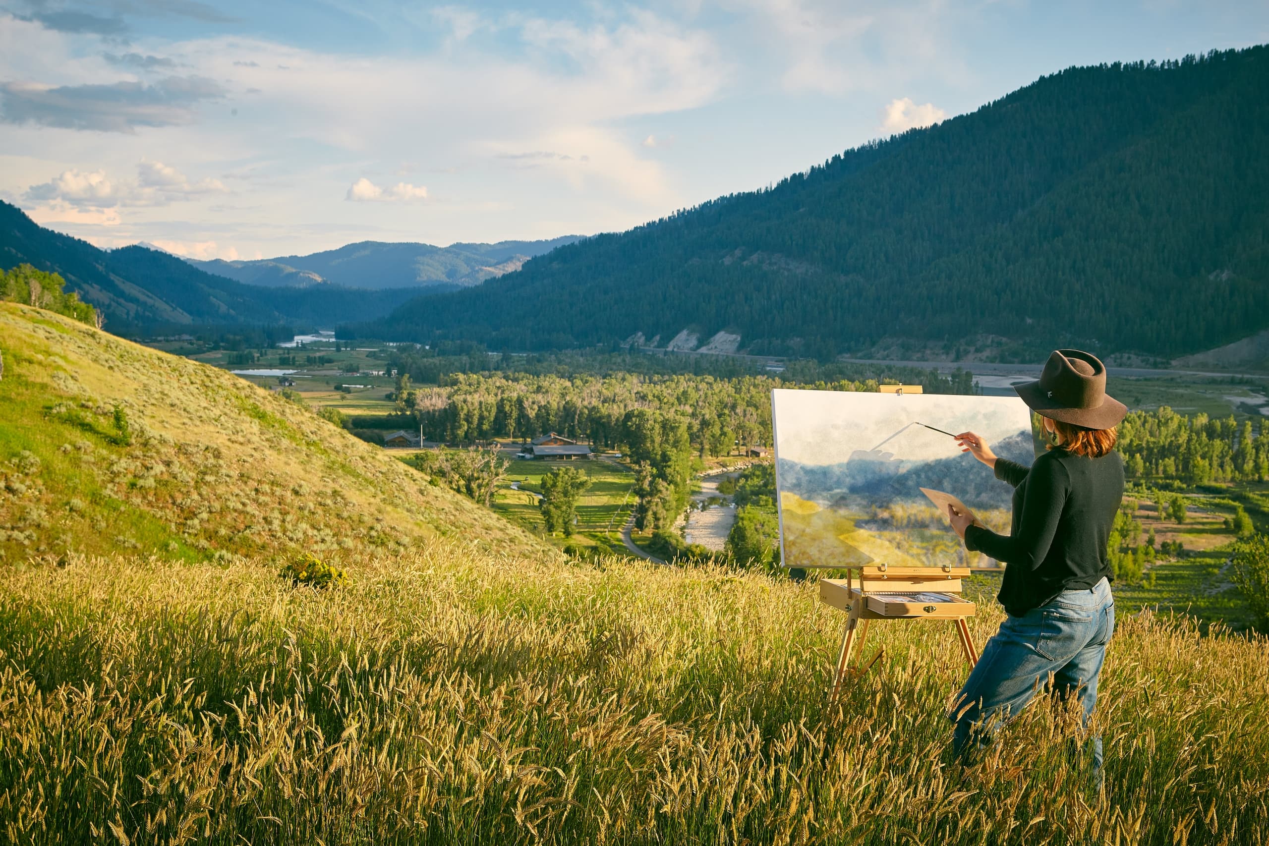 A woman painting outdoors at Snake River Sporting Club in Jackson, WY