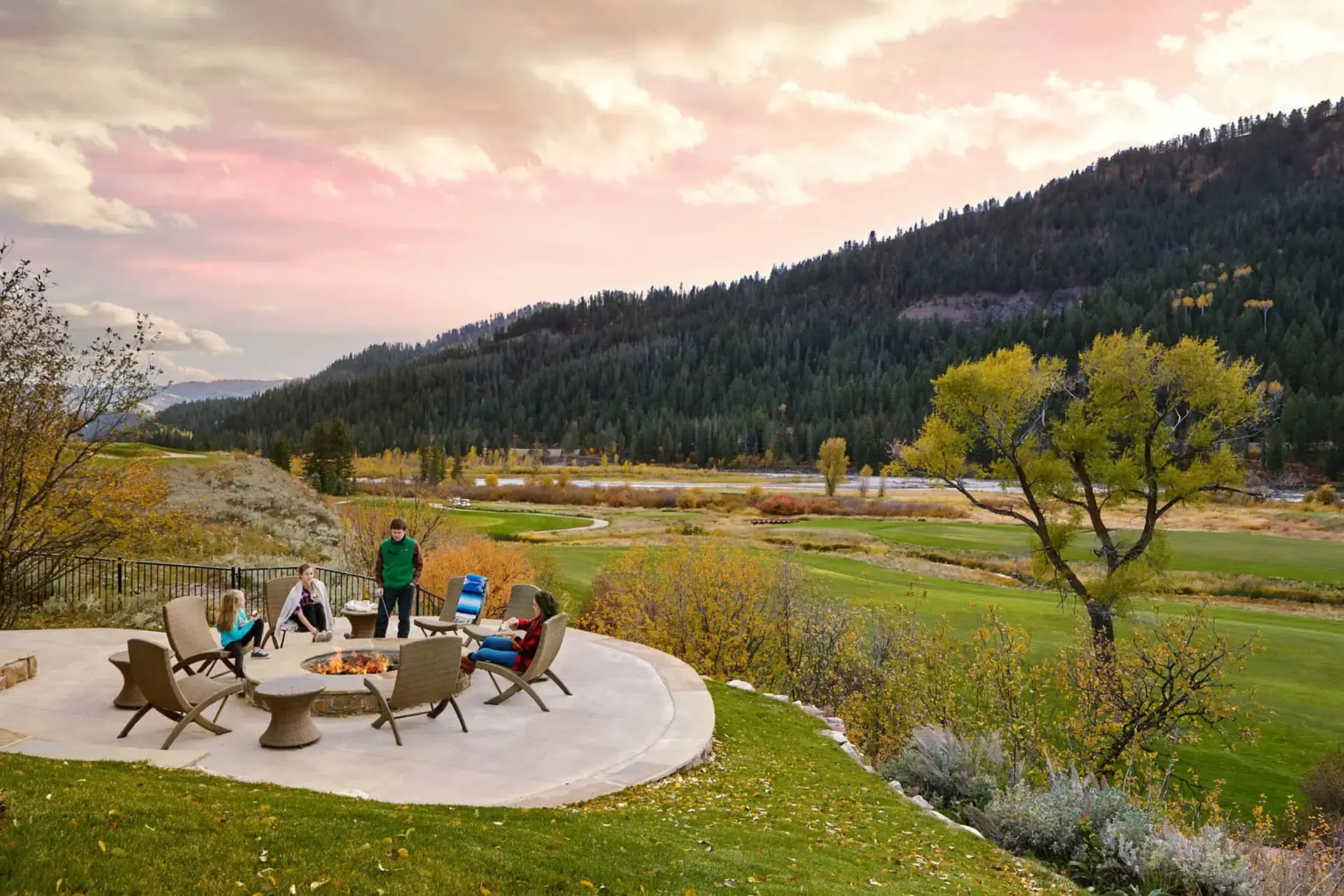 People enjoying the outdoor firepit and patio at the Snake River Sporting Club in Wyoming