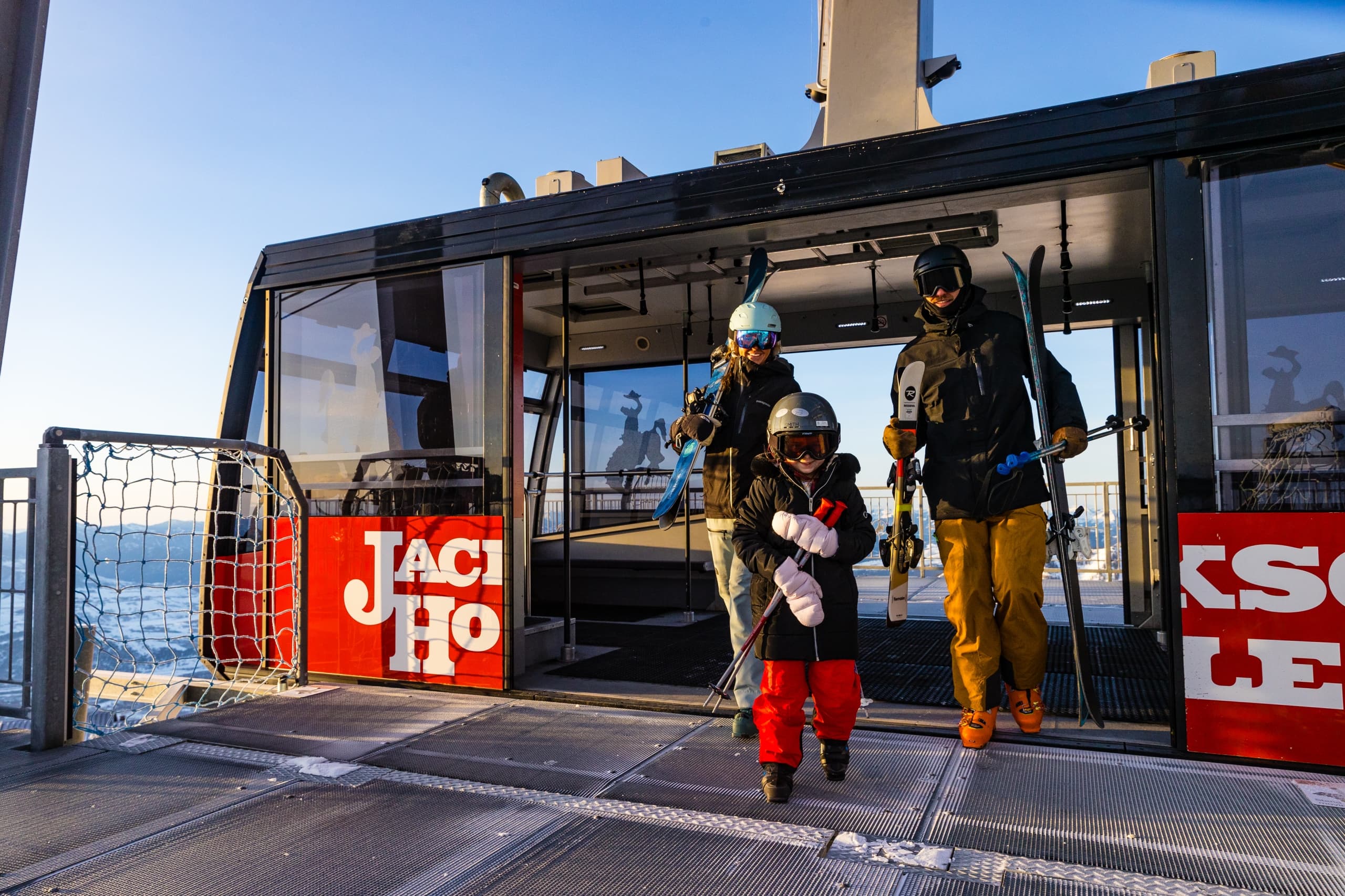A family with a young child stepping off the gondola at Jackson Hole Mountain Resort