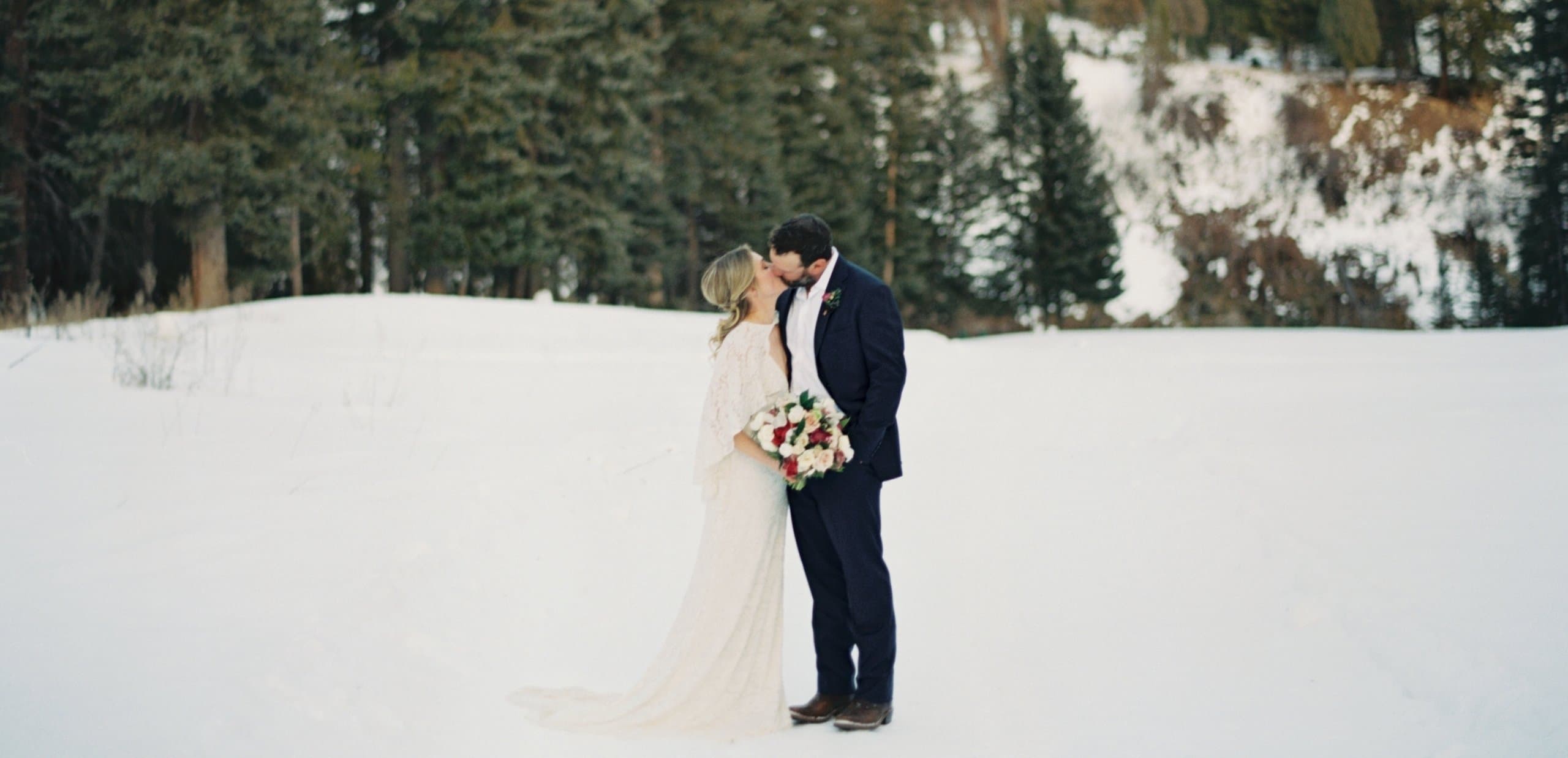 A bride and groom kissing outdoors in Jackson Hole during the winter.