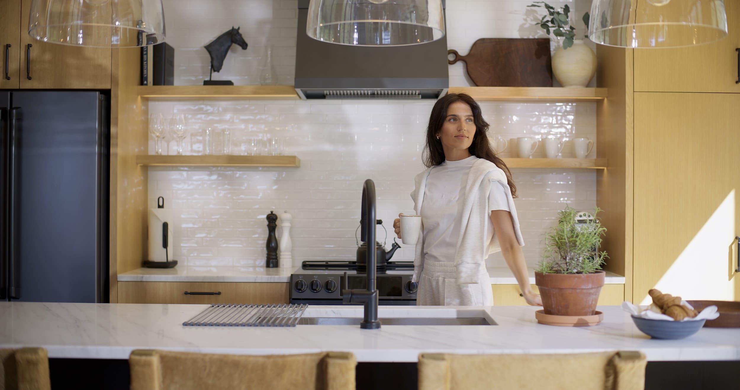 Guest in a modern cabin kitchen at Snake River Sporting Club in Jackson Hole, Wyoming