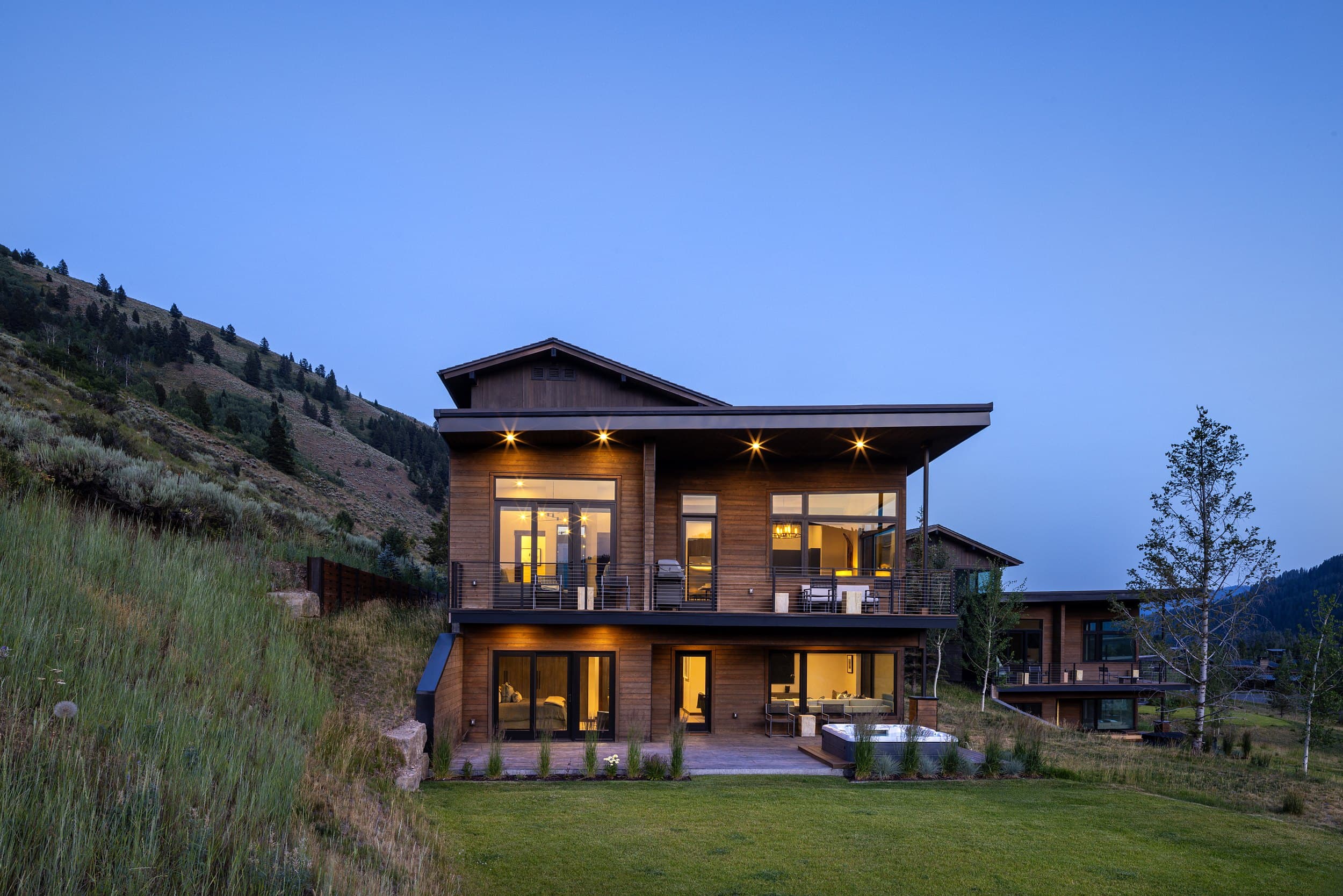 Modern luxury cabin exterior at dusk at Snake River Sporting Club in Jackson Hole, Wyoming